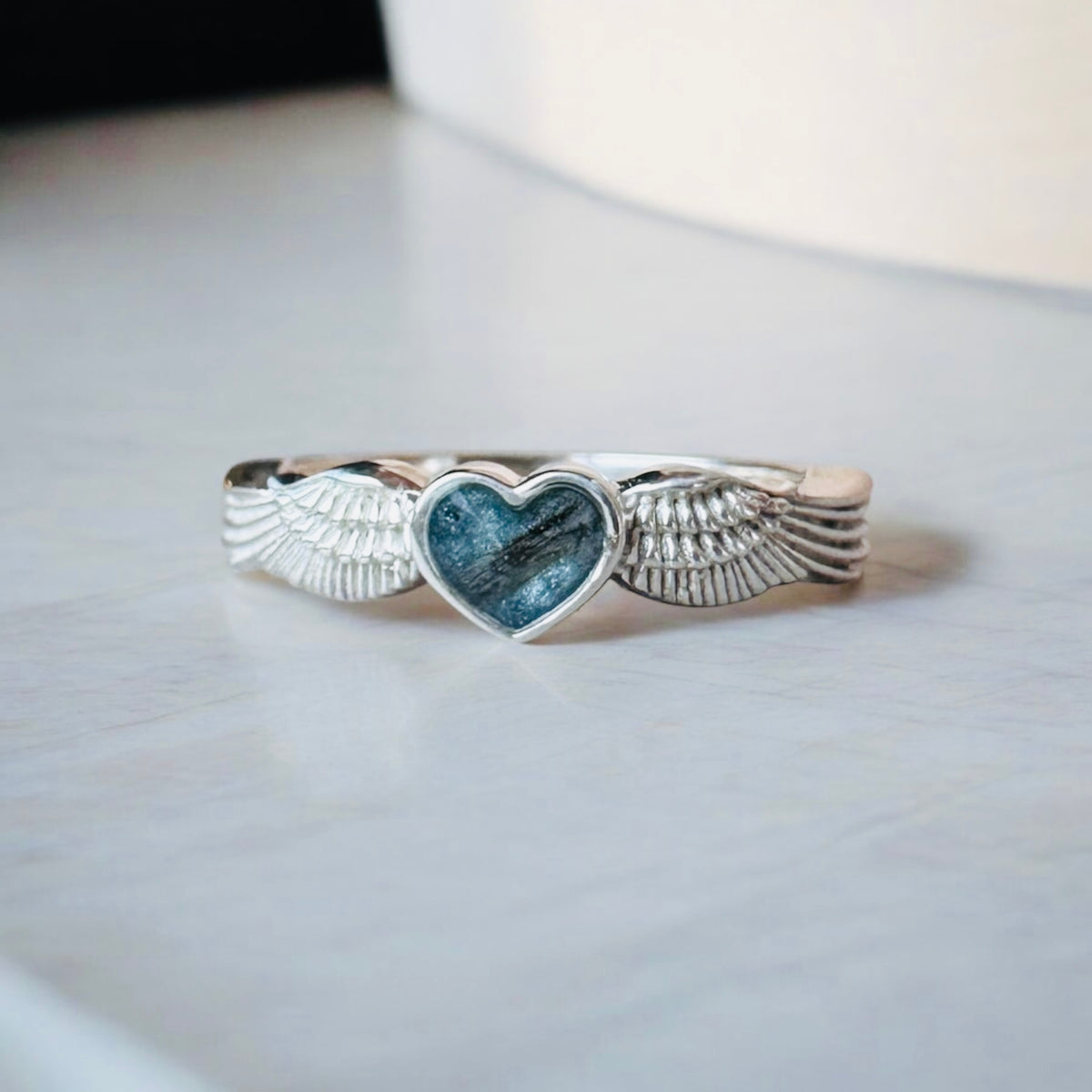 Sterling silver angel wings memorial keepsake ring, personalised with cremation ashes, breastmilk, umbilical cord, hair or pet fur. A meaningful design symbolising love, remembrance and protection. Handcrafted in West Wales by Afallon DNA Jewellery.