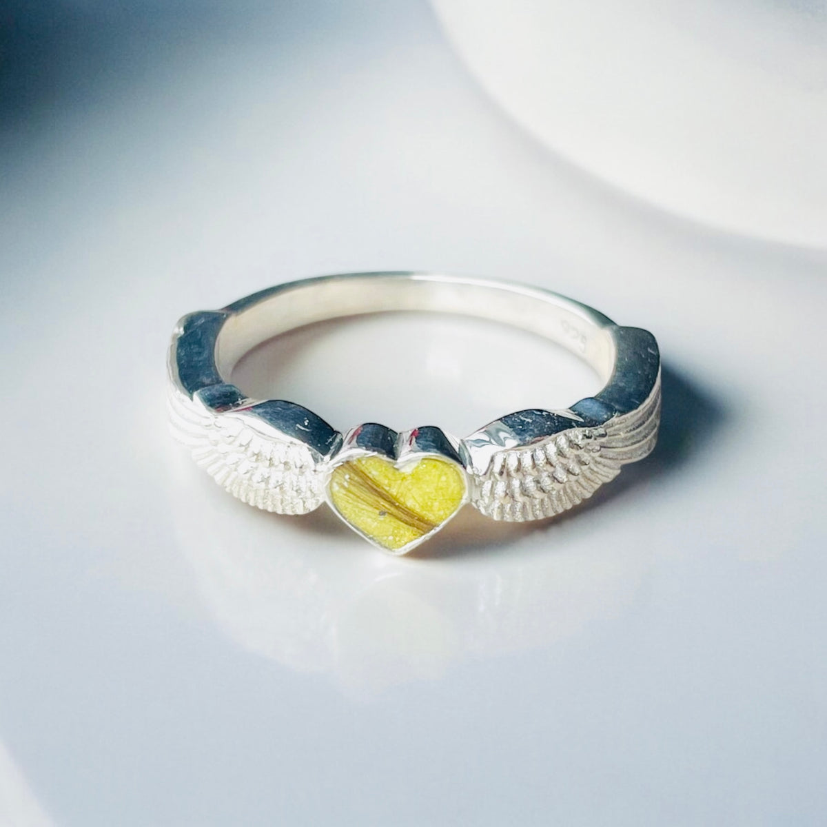 Sterling silver angel wings memorial keepsake ring, personalised with cremation ashes, breastmilk, umbilical cord, hair or pet fur. A meaningful design symbolising love, remembrance and protection. Handcrafted in West Wales by Afallon DNA Jewellery.