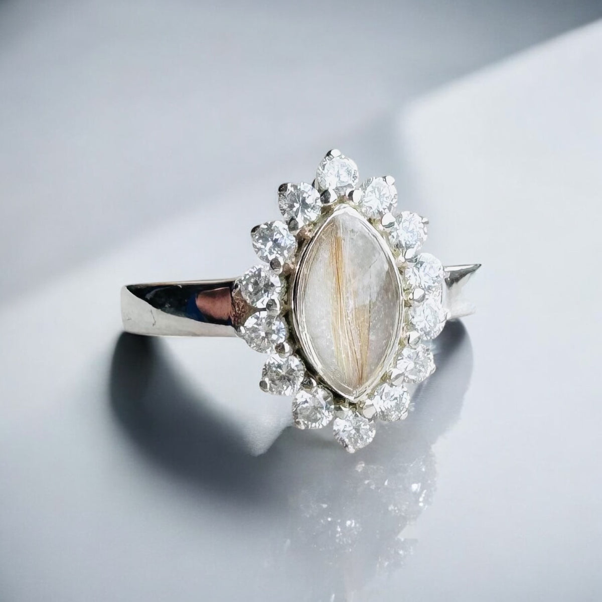 Sterling silver halo marquise keepsake ring with a breastmilk resin centre containing a strand of hair, surrounded by cubic zirconia stones.