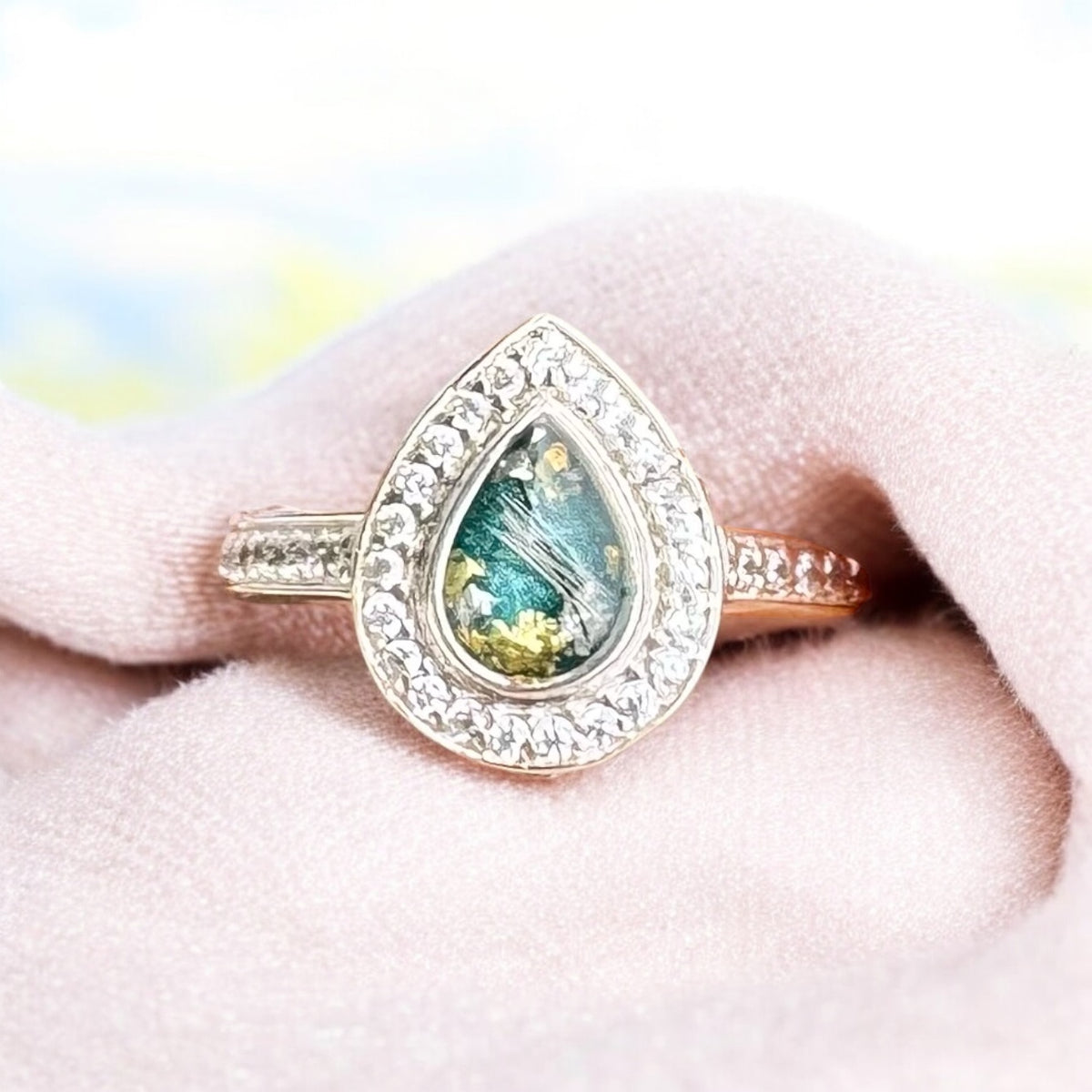 Elegant sterling silver halo pear keepsake ring, personalised with breastmilk, cremation ashes, umbilical cord, hair or pet fur. Featuring a sparkling crystal halo surrounding a pear-shaped setting. Handcrafted in West Wales by Afallon DNA Jewellery.