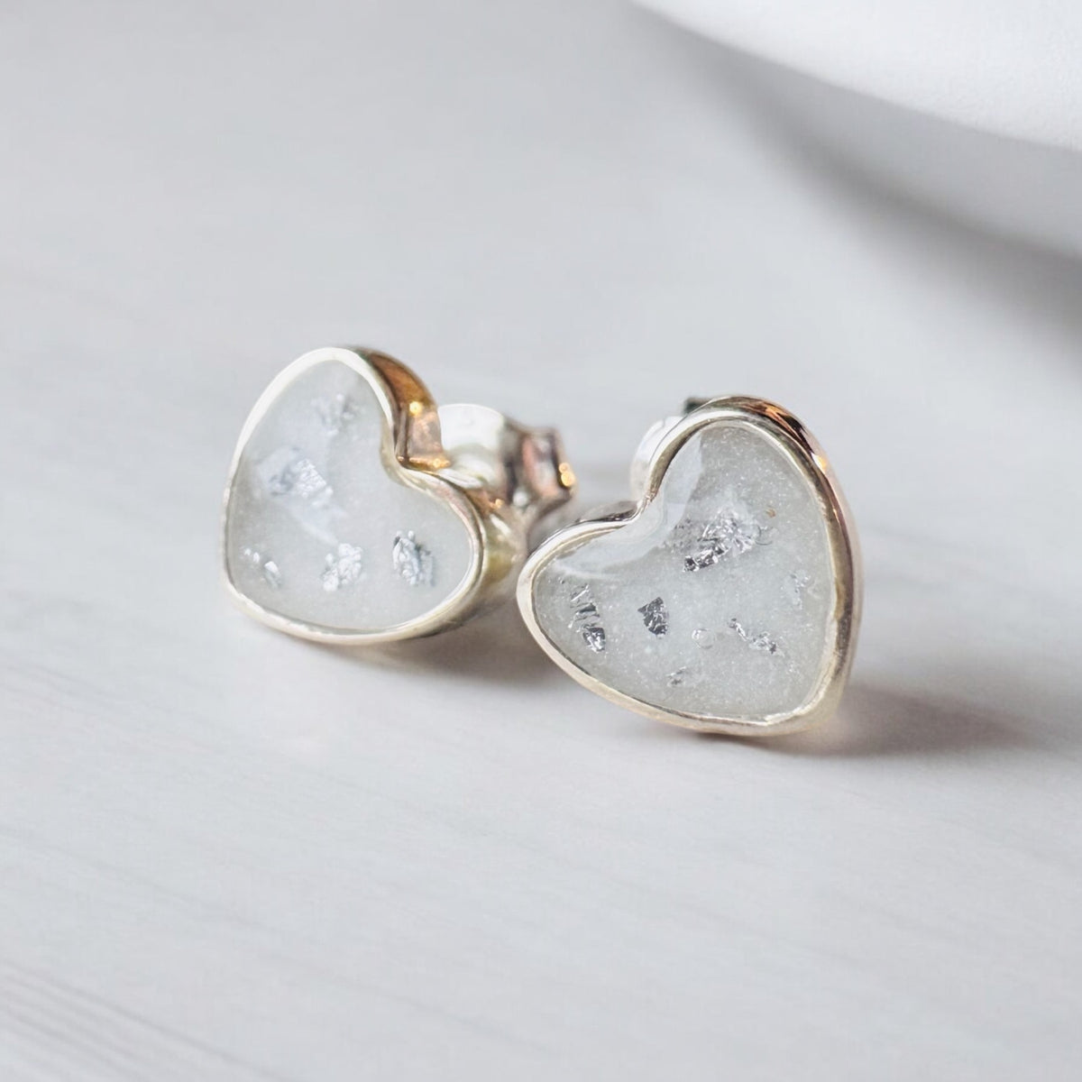 Beautiful sterling silver heart keepsake earrings, personalised with breastmilk, cremation ashes, umbilical cord, hair or pet fur. Delicate heart-shaped designs, handcrafted in West Wales by Afallon DNA Jewellery.