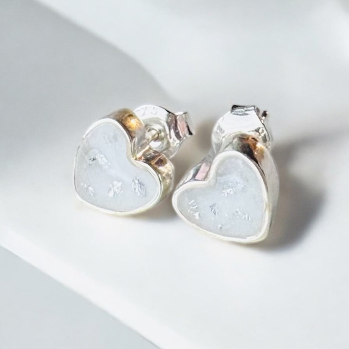 Beautiful sterling silver heart keepsake earrings, personalised with breastmilk, cremation ashes, umbilical cord, hair or pet fur. Delicate heart-shaped designs, handcrafted in West Wales by Afallon DNA Jewellery.