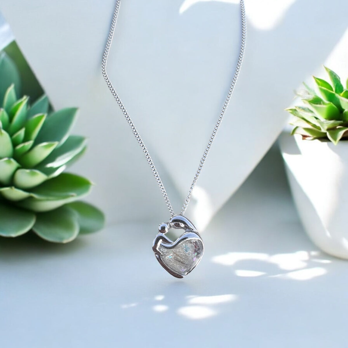 Sterling silver Mother's Love keepsake necklace, personalised with breastmilk, umbilical cord, cremation ashes, hair or pet fur. A beautiful sentimental pendant celebrating the bond between mother and child. Handcrafted in West Wales by Afallon DNA Jewellery.