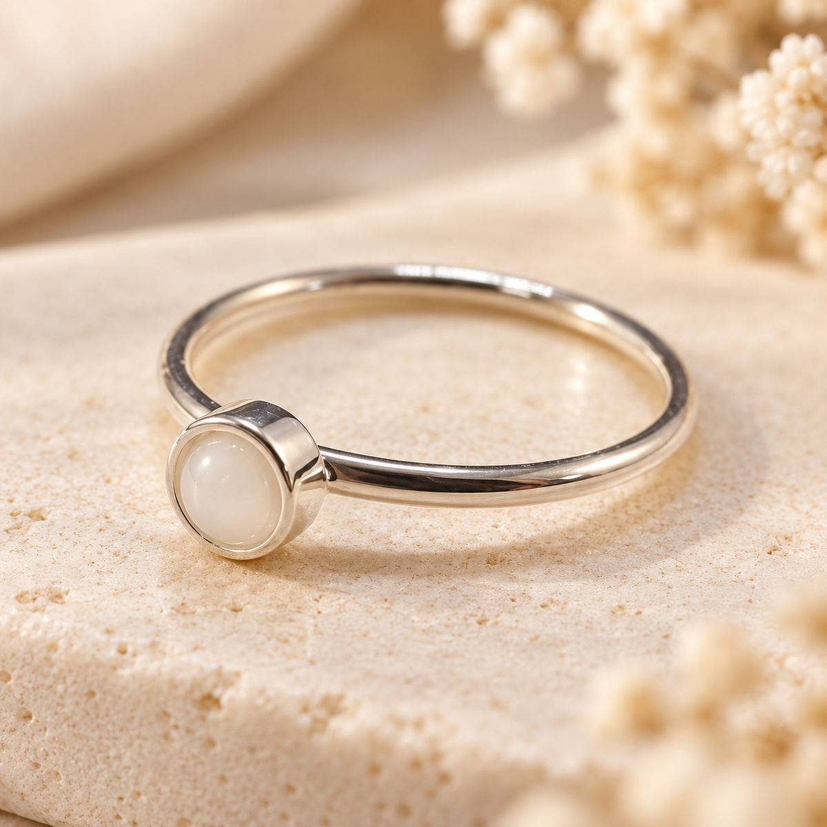 Delicate sterling silver petite round keepsake ring featuring a small breastmilk white resin stone and slim polished band.